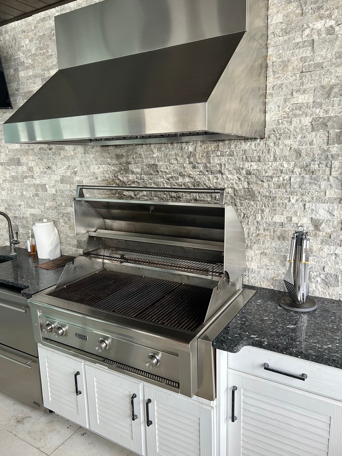 Clean Lynx built-in grill and stainless steel vent hood in a Tampa Bay outdoor kitchen